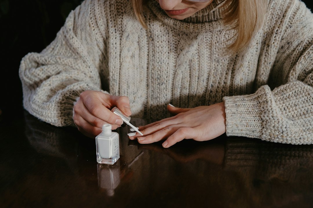 A nail professional carefully examining natural nails during a consultation