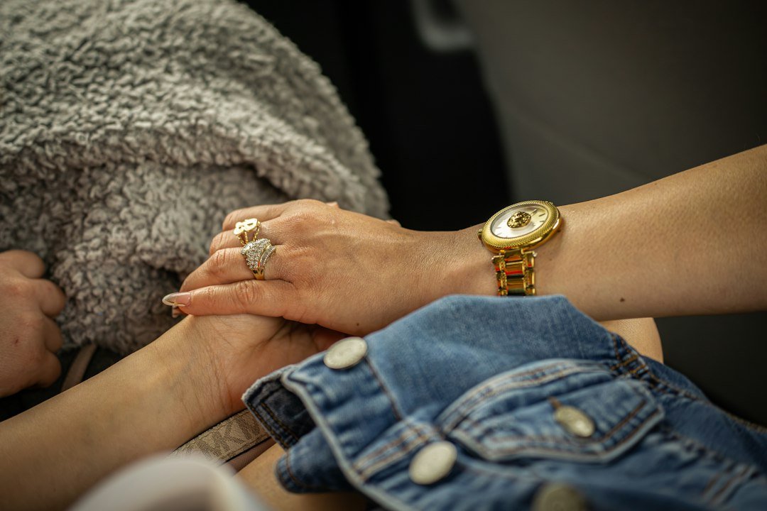 Two hands holding each other with a watch